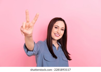 Photo of gorgeous glad candid lady wear stylish grey clothes demonstrate v-sign greetings symbol isolated on pink color background