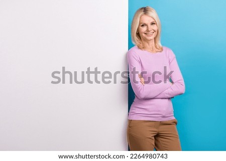 Photo of gorgeous positive senior lady wear stylish clothes presenting empty space banner poster board isolated on blue color background