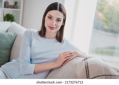 Photo of gorgeous satisfied lady sit couch look camera enjoy spend pastime house indoors