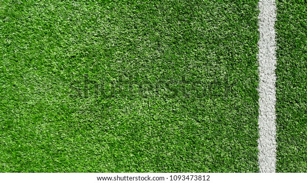 Photo of a green synthetic grass sports field with\
white line shot from\
above.