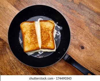 Photo of a grilled cheese sandwich cooking in a large frying pan.  - Powered by Shutterstock