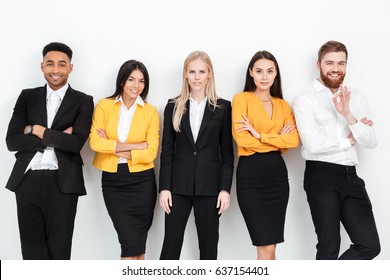 Photo Of A Group Of Concentrated Colleagues Standing In Office Posing. Looking At Camera.