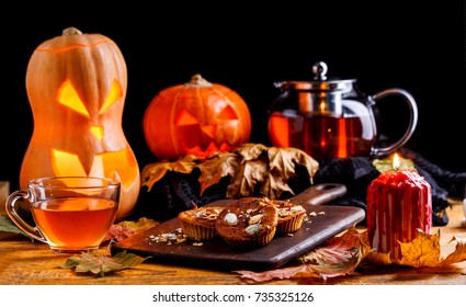 Photo Of Halloween Pumpkins, Cakes, Cup Of Tea On Black Background
