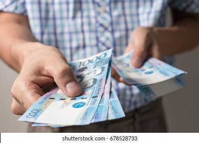 Photo of hands holding bundle of blue money in cash of one thousand philippines peso as if being rich, boastful. Show off, pay bills or give bribe. Payment procedure