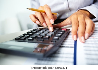 Photo hands holding pencil   pressing calculator buttons over documents