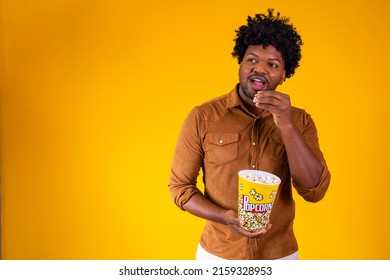 Photo Of Handsome Black Guy Eating Popcorn On Yellow Background. Entertainment Concept