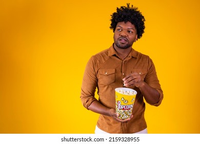 Photo Of Handsome Black Guy Eating Popcorn On Yellow Background. Entertainment Concept