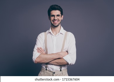 Photo Of Handsome Business Man Hands Crossed Toothy Beaming Smiling Young Chief Dressed Formalwear White Shirt Beige Suspenders Specs Isolated Grey Color Background