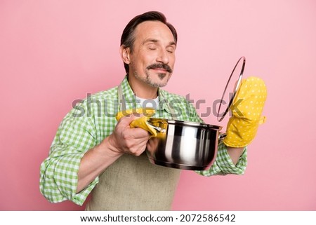 Photo of handsome dreamy man wear checkered shirt beige apron enjoying prepared dish aroma isolated light pastel pink color background