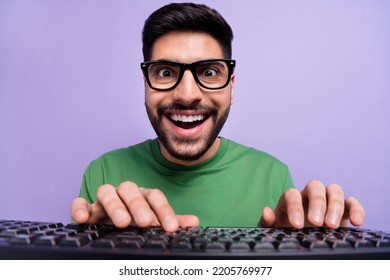 Photo of handsome geek nerd coder in spectacles green pullover writing code making new application isolated on purple color background
