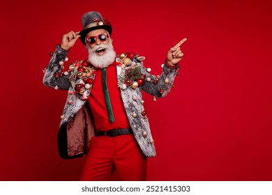 Photo of handsome good mood santa claus wear suit smiling enjoying xmas showing finger emtpy space isolated red color background - Powered by Shutterstock