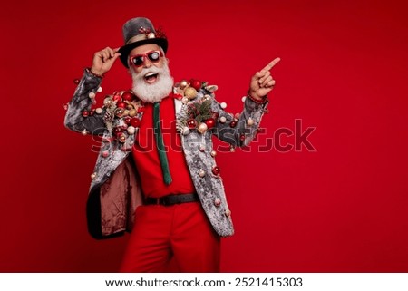 Photo of handsome good mood santa claus wear suit smiling enjoying xmas showing finger emtpy space isolated red color background