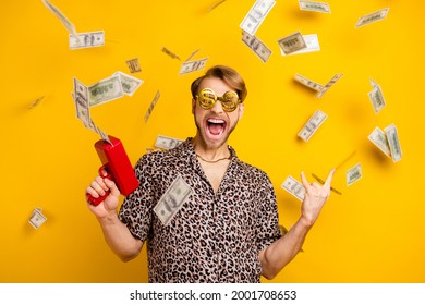 Photo of handsome rude gentleman dressed shirt dark glasses shooting money gun showing rock sign isolated yellow color background