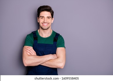 Photo of handsome virile muscles guy hold arms crossed self-confident best manual worker skilled engineer wear green t-shirt blue safety dungarees isolated grey background