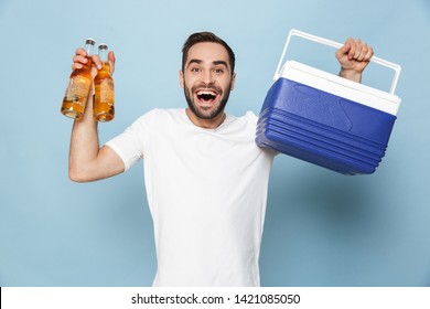 Photo Of Happy Caucasian Man In Casual White T-shirt Laughing While Carrying Cooler Box With Beer Bottles During Summer Party Isolated Over Blue Background