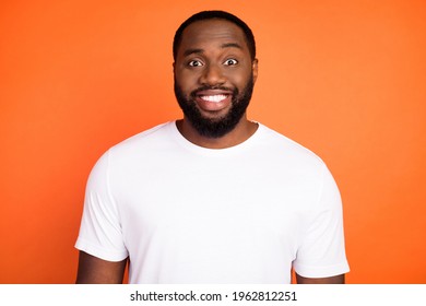 Photo Of Happy Charming Dark Skin Man Smile Good Mood Wear White T-shirt Isolated On Orange Color Background