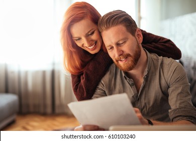 Photo Of A Happy Couple Doing Finances At Home.