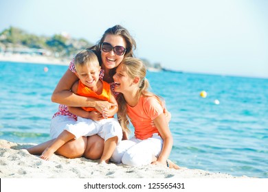 Photo Of Happy Family Laughing And Looking At Camera On The Beach