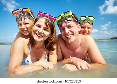 Photo of happy family looking at camera during summer vacation