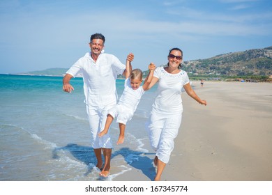 Photo Of Happy Family Running On The Beach