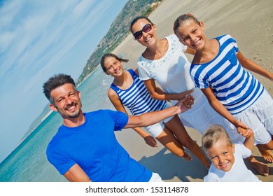 Photo Of Happy Family With Three Kids Running Down The Beach