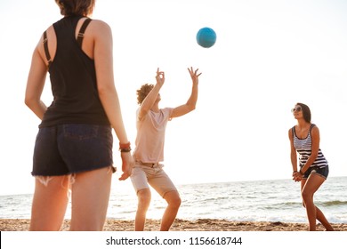Photo of happy friends outdoors on the beach play volleyball having fun. - Shutterstock ID 1156618744