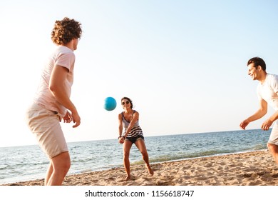 Photo of happy friends outdoors on the beach play volleyball having fun. - Shutterstock ID 1156618747