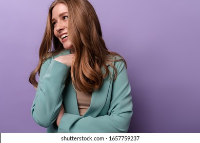 Photo Of A Happy Laughing Woman Posing Indoors Isolated Over Purple Wall Background.