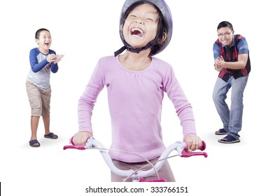 Photo of happy little girl wearing helmet and try to ride a bicycle with her family on the back, isolated on white background - Powered by Shutterstock