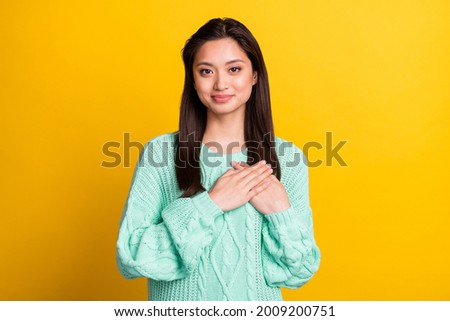Photo of happy nice charming woman hold hands heart honest smile isolated on yellow color background