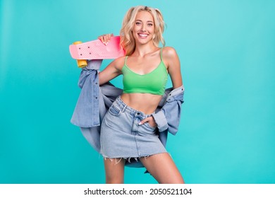 Photo of happy positive attractive woman hold longboard good mood smile isolated on blue color background