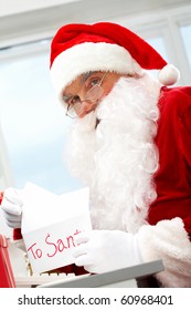 Photo Of Happy Santa Claus Opening Letter With Christmas Wish