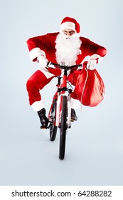 Photo of happy Santa Claus with red sack on bike