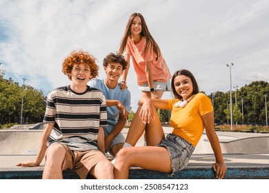 Photo of happy smiling friends teenagers high school pupils college students spending time summer holiday having fun meeting hanging out outside in skate green nature park looking at camera - Powered by Shutterstock