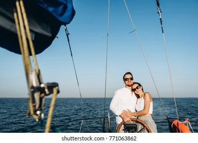 Photo of a happy spouses who spend the weekend on a yacht swimming by the sea on a beautiful sunset