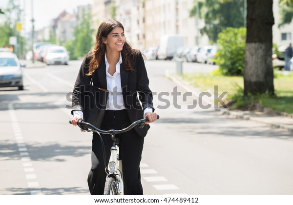 Photo\
Of Happy Young Businesswoman Commuting On\
Bicycle