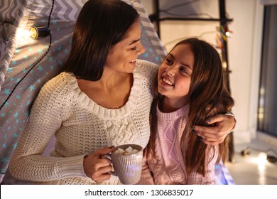 Photo of a happy young woman with her little daughter girl on floor holding cocoa drinking. Christmas concept. స్టాక్ ఫోటో