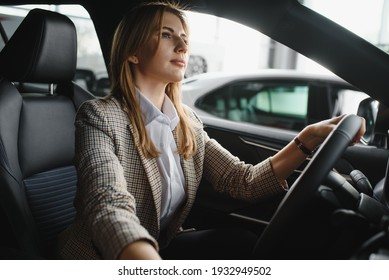 Photo of happy young woman sitting inside her new car. Concept for car rental - Shutterstock ID 1932949502