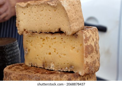 Photo of head of handcrafted hard cheese on a village fair. Selective focus. High quality photo