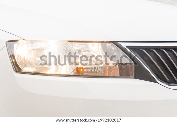 Photo of a headlight of a car. Car headlight and\
radiator grill