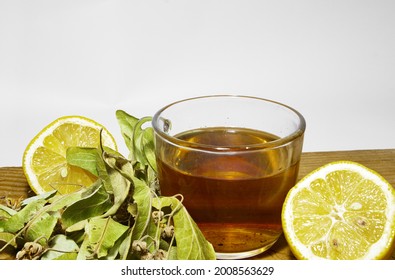 Photo Of Herbal And Linden Tea Inside The Glass Pot Together With Linden Tea Leaves And Broken And Not Broken Walnuts On The Wood Table.