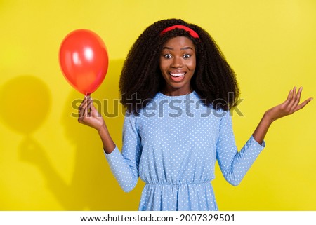 Photo of hooray curly hairdo young lady hold balloon wear blue blouse isolated on vivid yellow color background