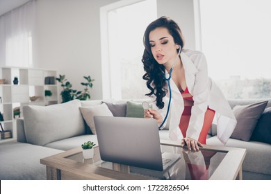 Photo Of Hot Sexy Tempting Lady Work Home Remote Online Notebook Chat Play Naughty Nurse Role Listen Stethoscope Heart Beating Client Bend Chest To Screen Wear Lab Coat Red Bikini Indoors