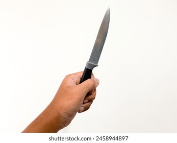 Photo of human hand holding a knife in a white wall background