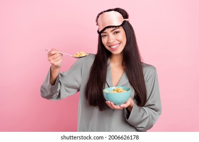 Photo of hungry adorable woman nightwear mask smiling eating morning oat flakes porridge isolated pink color background - Powered by Shutterstock