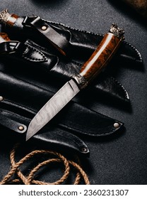 Photo of a hunting knife lying on top of many knives
