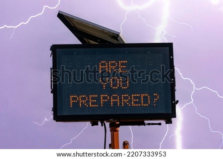 Photo illustration of digital road sign in front of lightning with text Are You Prepared ? to convey a concept of preparedness for severe weather and power outages.