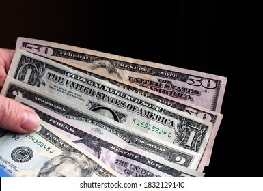 A Photo Illustration Of US Various Dollar Bills In Woman Hand. Selective Focus. 20  Dollars Bill At Foreground