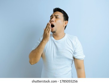 Photo Image Portrait Asian Young Man Yawning And Covering Wide Open Mouth With Hand