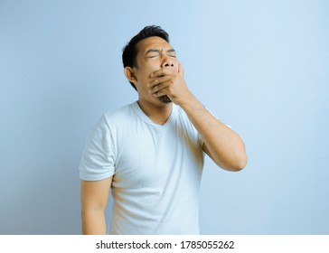 Photo Image Portrait Asian Young Man Yawning And Covering Wide Open Mouth With Hand